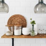 two clear glass jars on brown wooden floating shelf